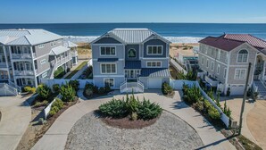 A beachfront property with a central building featuring a porch and a small garden.