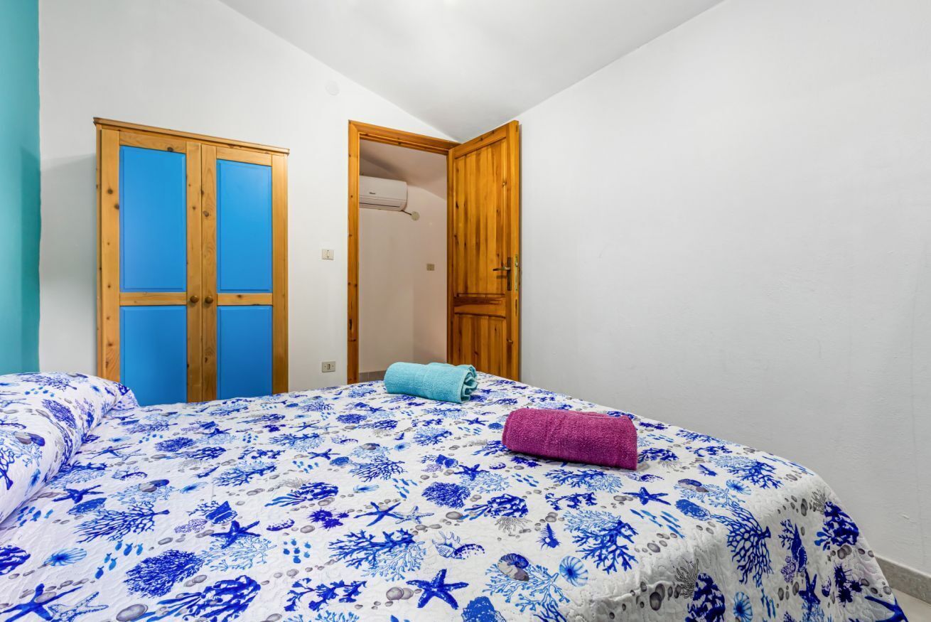 Ein Schlafzimmer mit einem Bett, zwei Türen und einem Handtuch auf dem Bett.