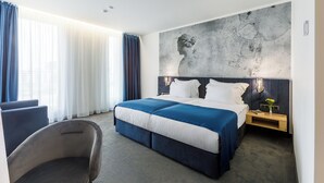 A modern hotel room with a large bed, a desk, and a chair. - Blue Star Luxury Hotel (Sofia)