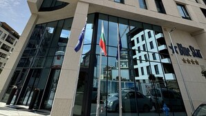 A modern building with a glass entrance, flags, and the Blue Star logo. - Blue Star Luxury Hotel (Sofia)