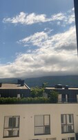 Un edificio con múltiples ventanas y vista al cielo con nubes.