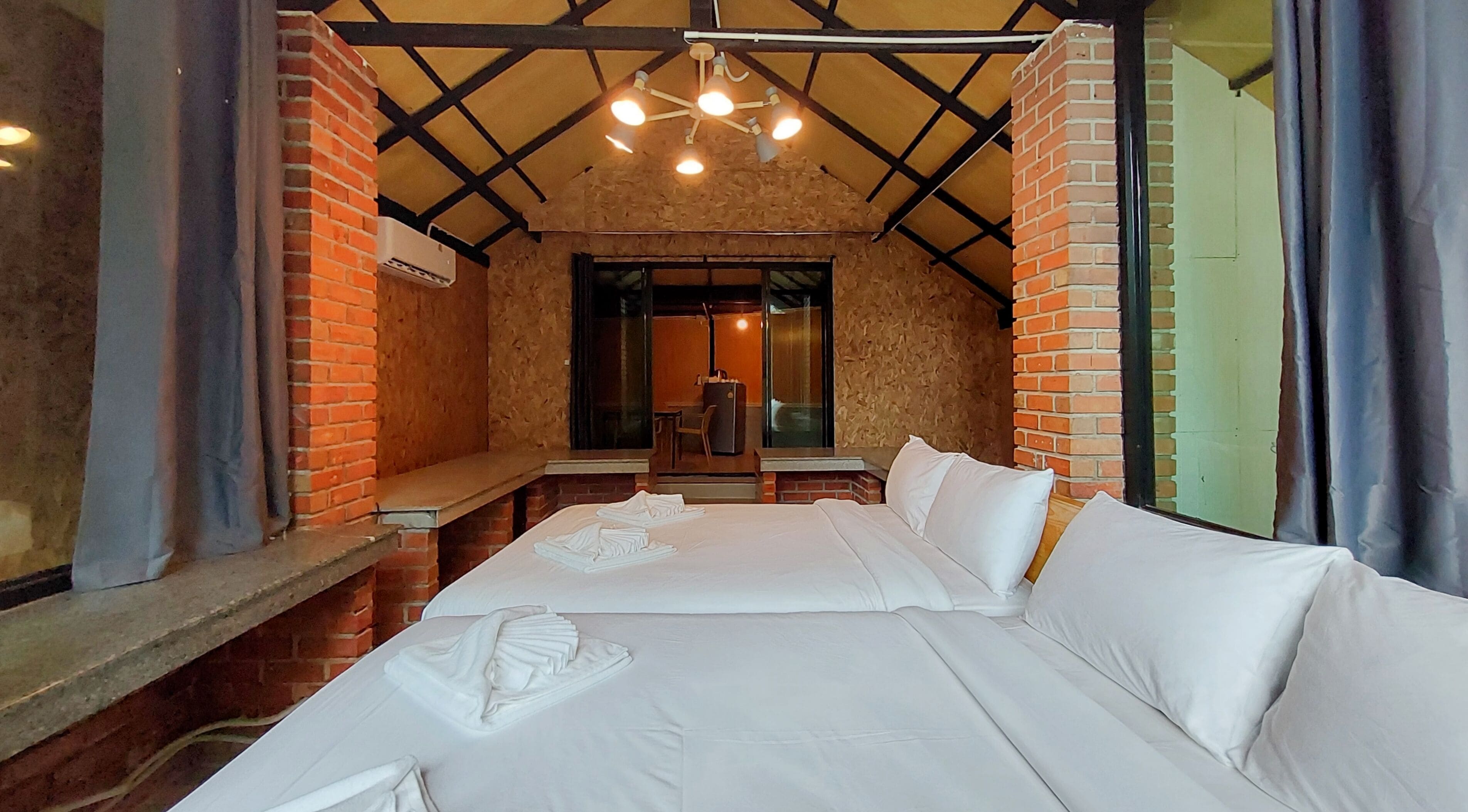 Una stanza con un letto, una panca, un tavolo e una sedia.