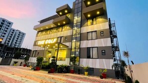 A hotel named "The Golf" with a modern design, featuring multiple floors and a well-lit entrance. - Hotel The Golf (Lucknow)