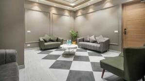 A modern waiting area with two sofas, a coffee table, and a checkered floor. - Hotel The Golf (Lucknow)