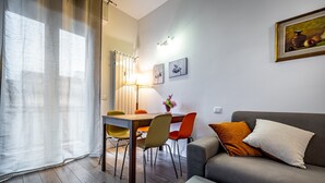 A modern living room with a sofa, a dining table with chairs, and a lamp. - YiDCefalonia (Florence)