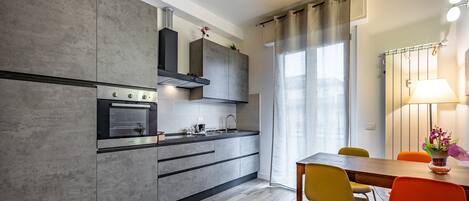 Apartamento, vistas a la ciudad | Cocina privada | Frigorífico grande, horno, placa de cocina y utensilios de cocina