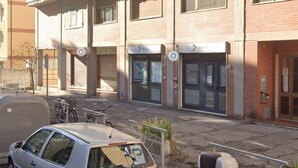 A building with closed shutters, a visible entrance, and a parking area with a car and bicycles. - YiDCefalonia (Florence)