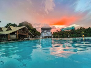 Une piscine avec un poste de surveillance pour les sauveteurs et un bâtiment en bois en arrière-plan.