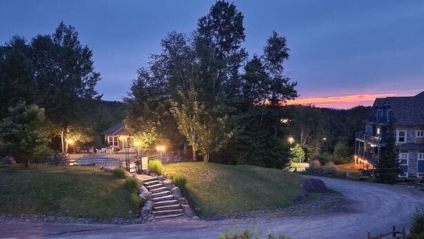 A residential driveway leading to a house with a stone pathway and a small bridge over a gravel path. - Mont Blanc Classic Chalet • Ski-in/Ski-out (Mont Blanc)