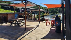An outdoor deck with picnic tables, a barbecue grill, and a shaded area with umbrellas. - Mont Blanc Classic Chalet • Ski-in/Ski-out (Mont Blanc)