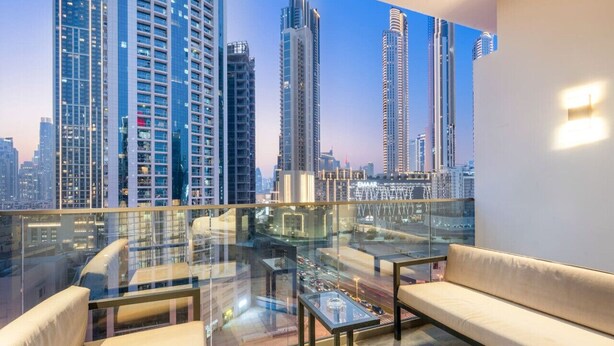 A modern room with a glass balcony, a sofa, and a small table.