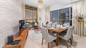 A modern dining area with a city view, a large window, and a contemporary chandelier.