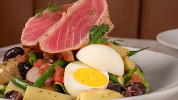 Una ensalada con diferentes verduras y una porción de carne.
