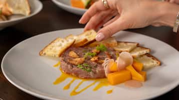 Un plato de comida con un guiso de carne, pan y verduras.
