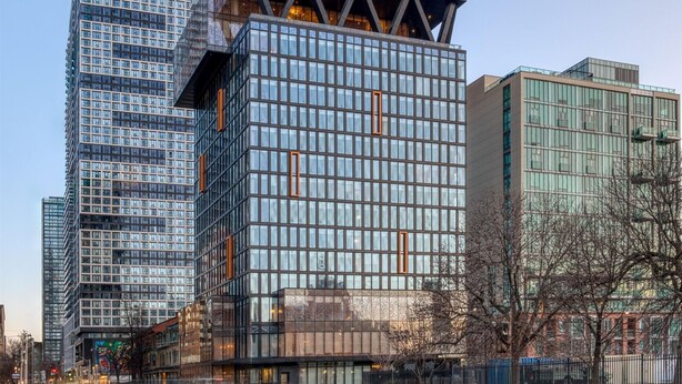 Ein modernes Hochhaus mit dem Schriftzug "TOOR" auf der Spitze.