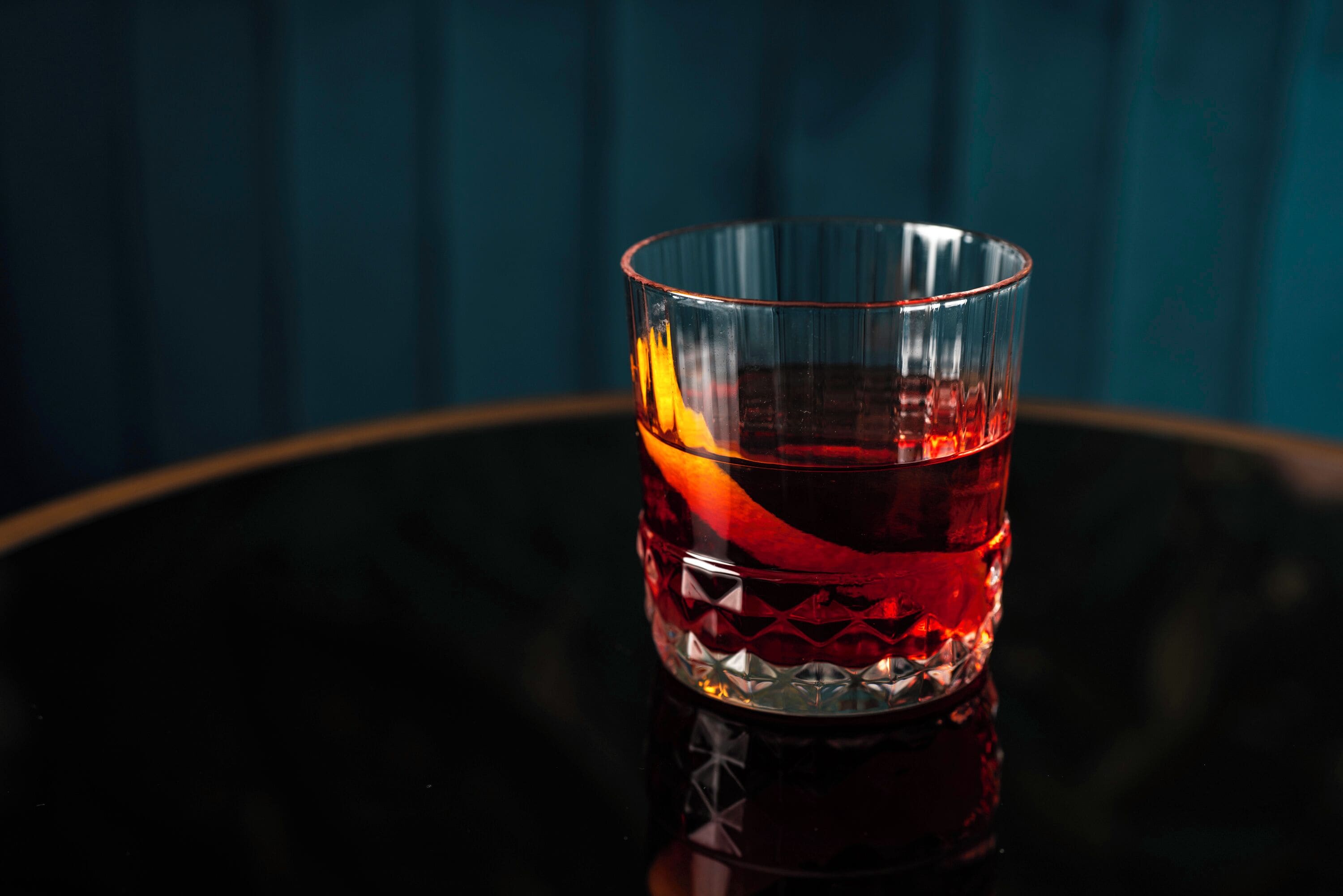 Een glas met een reliëfpatroon op een reflecterend oppervlak.