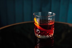 Een glas met een reliëfpatroon op een reflecterend oppervlak.
