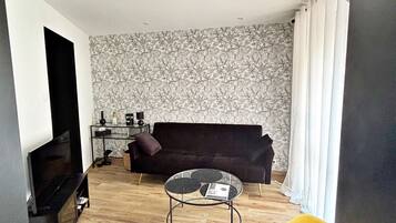 A living room with a sofa, a coffee table, and a TV stand.