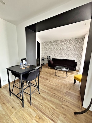 A modern living space with a dining area, a sofa, and a coffee table. - Arum Suite with Terrace (Roanne)