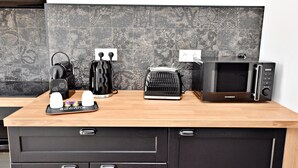 A kitchen counter with a toaster, kettle, and microwave. - Arum Suite with terrace (Roanne)