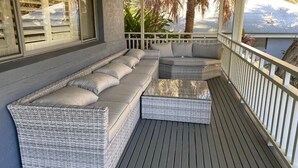 A covered outdoor seating area with wicker furniture and a wooden deck. - Wild Duck Holiday Home at Rafferty's Resort (Cams Wharf)