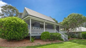 A two-story house with a covered porch, a staircase, and a well-maintained lawn. - Wild Duck Holiday Home at Rafferty's Resort (Cams Wharf)