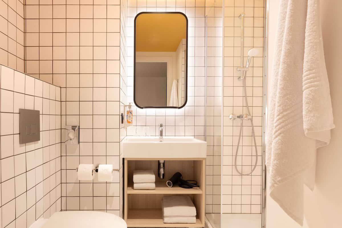 A modern bathroom with a toilet, sink, and shower.