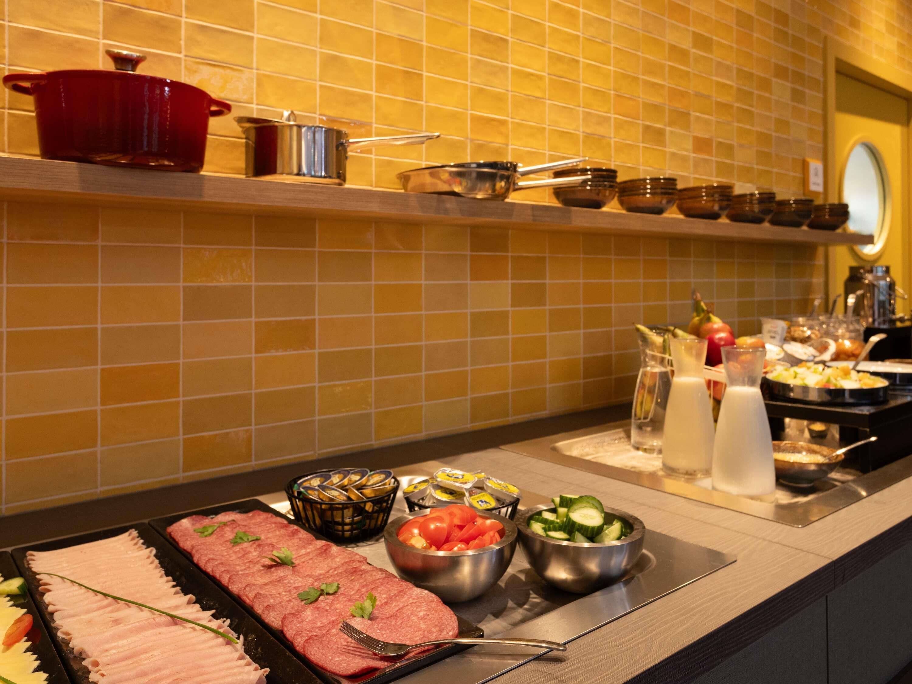 A buffet setup with various food items and utensils.