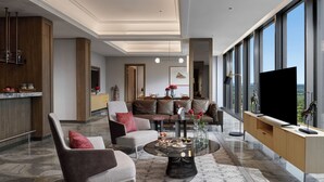 Un salon moderne avec un canapé, des fauteuils, une table basse et un téléviseur.