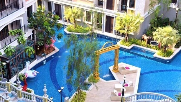 A luxurious indoor pool area with multiple levels, a central fountain, and a golden gazebo. - Espana Condo Resort Pattaya Office (Pattaya)