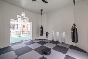 A room with a checkered floor, a punching bag, and a ceiling fan. - Espana Condo Resort Pattaya Office (Pattaya)