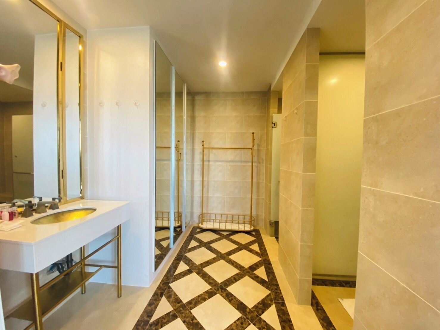 A modern bathroom with a white sink, large mirror, and a shower area.