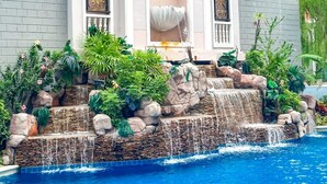A hotel with a pool, a waterfall feature, and decorative arches. - Espana Condo Resort Pattaya Office (Pattaya)