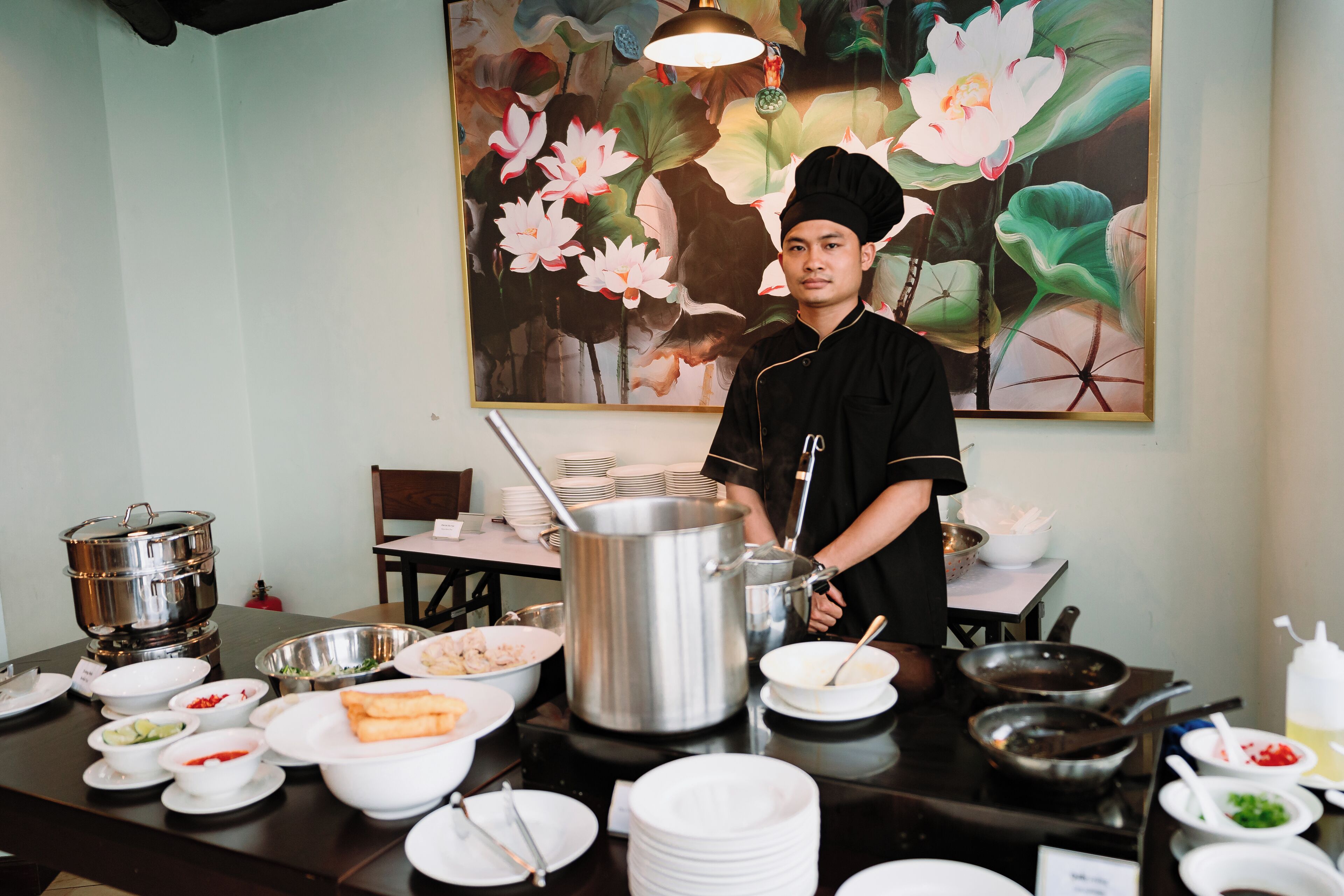 A buffet setup with various dishes and cooking equipment.