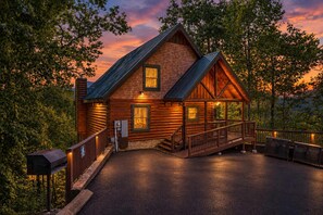 Une cabane en rondins avec une véranda, un escalier et une boîte aux lettres.