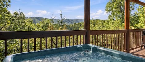 Relax in the private hot tub beneath the mountain sky.