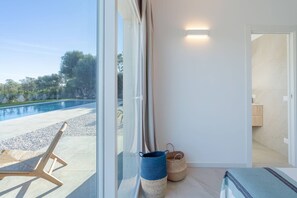A room with a large window, a wooden chair, and two woven baskets. - Charming Villa in Fontane Bianche, Italy - Perfect for Families (Syracuse)