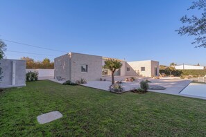 A modern house with a swimming pool, a small garden, and a garage. - Charming Villa in Fontane Bianche, Italy - Perfect for Families (Syracuse)