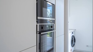 Een moderne keuken met een ingebouwde oven en een wasmachine.