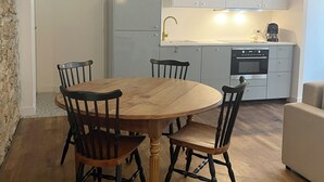 A compact kitchen with white cabinets, a built-in oven, and a coffee maker.