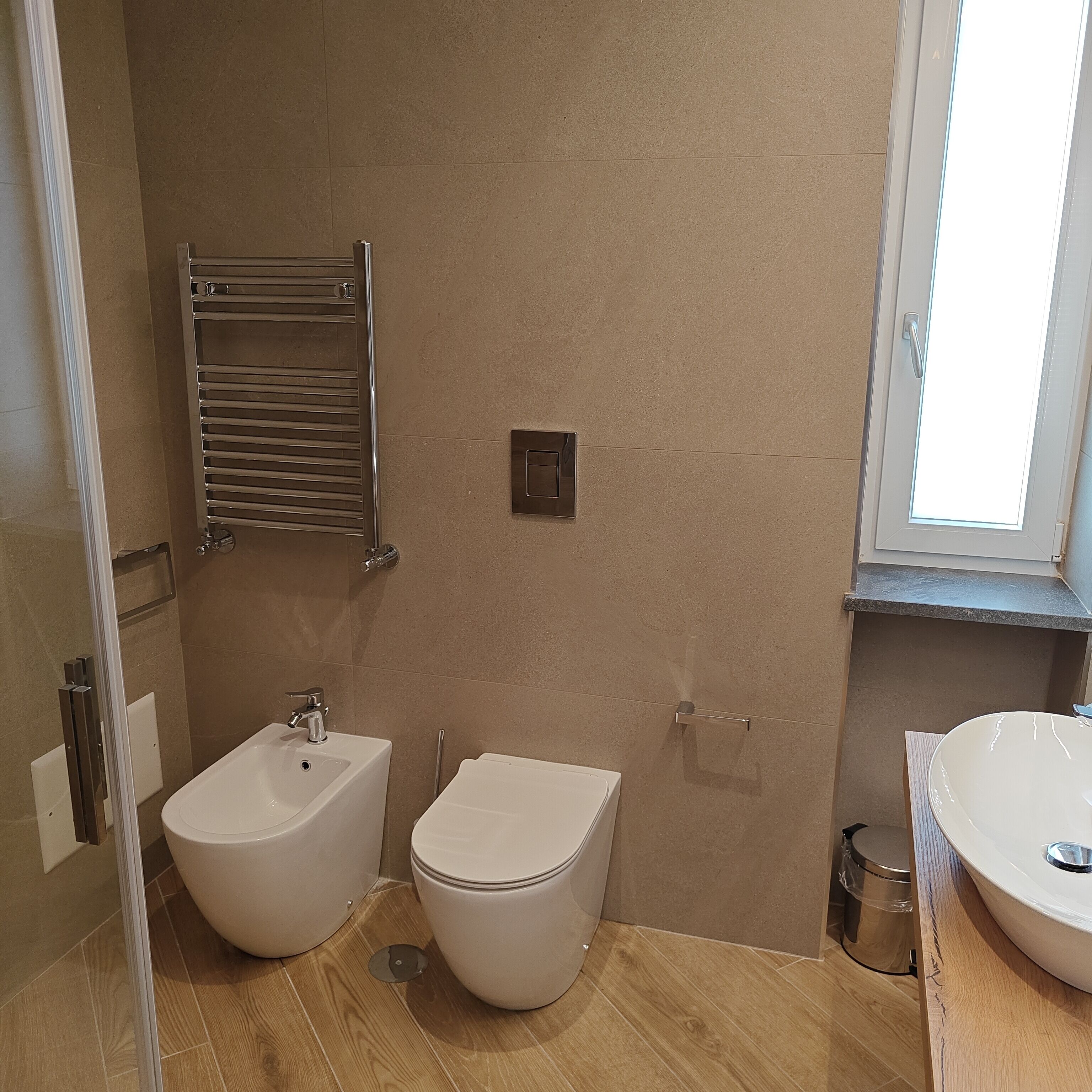 A bathroom with a bidet, toilet, and sink.