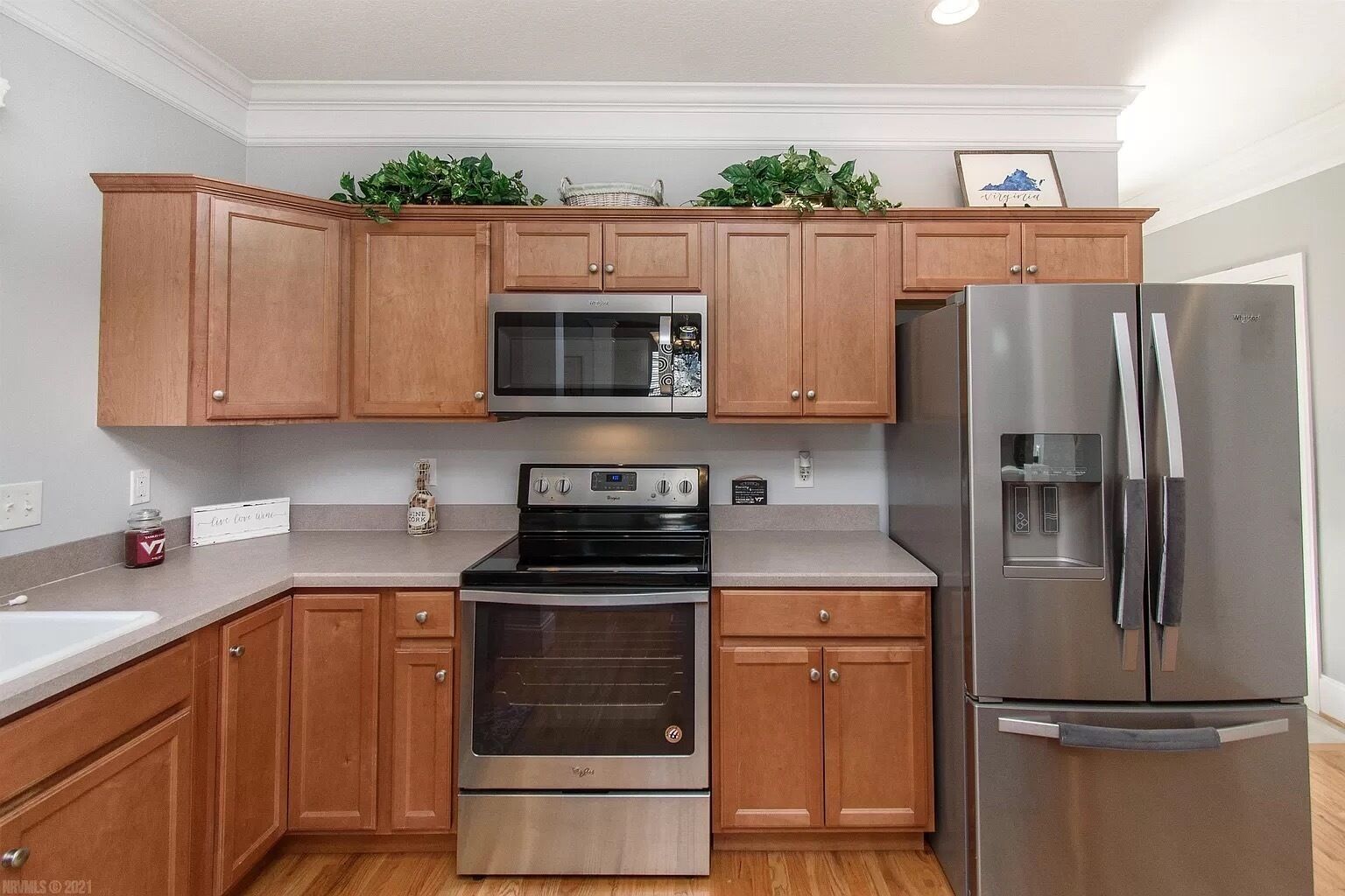 A modern kitchen with wooden cabinets, stainless steel appliances, and a built-in oven.