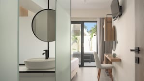 A modern bathroom with a large round mirror, a white sink, and a built-in television. - Mousses Villa, with Pool & Spa Whirlpool by the Beach (CQ4M+QX3 Bali, Greece)