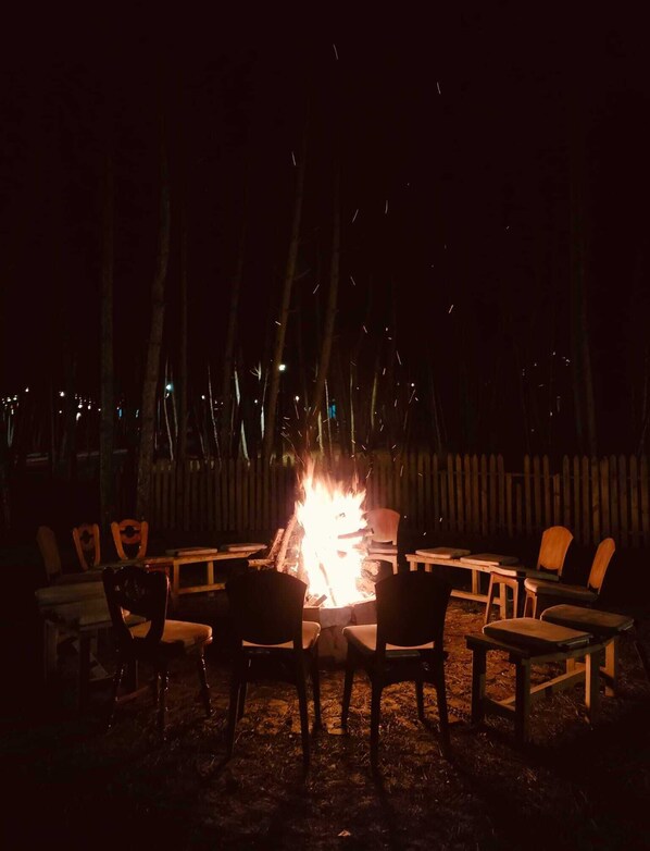 A campfire surrounded by outdoor seating. - ÇAMPINARI DOĞA EVLERİ & RESTAURANT (Mengen)