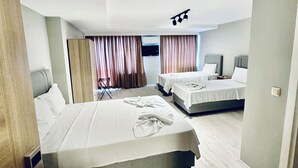 A modern hotel room with a large bed, a smaller bed, and a desk area. - The Hera Gold Hotel (Istanbul)