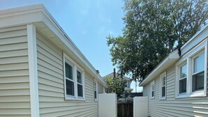 Un quartier résidentiel comprenant deux maisons, une pelouse et un arbre.