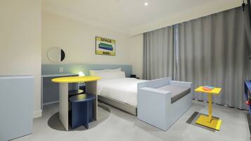 Relax in a stylish room with a neatly made bed, a small table, and a comfortable chair.