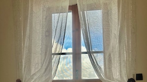 A room with a wooden door and a window with floral curtains. - A Pochi Kilometri dal Mare di Sabaudia e dal Parco del Circeo, Piscina Esterna (Zona Industriale Borgo San Donato)