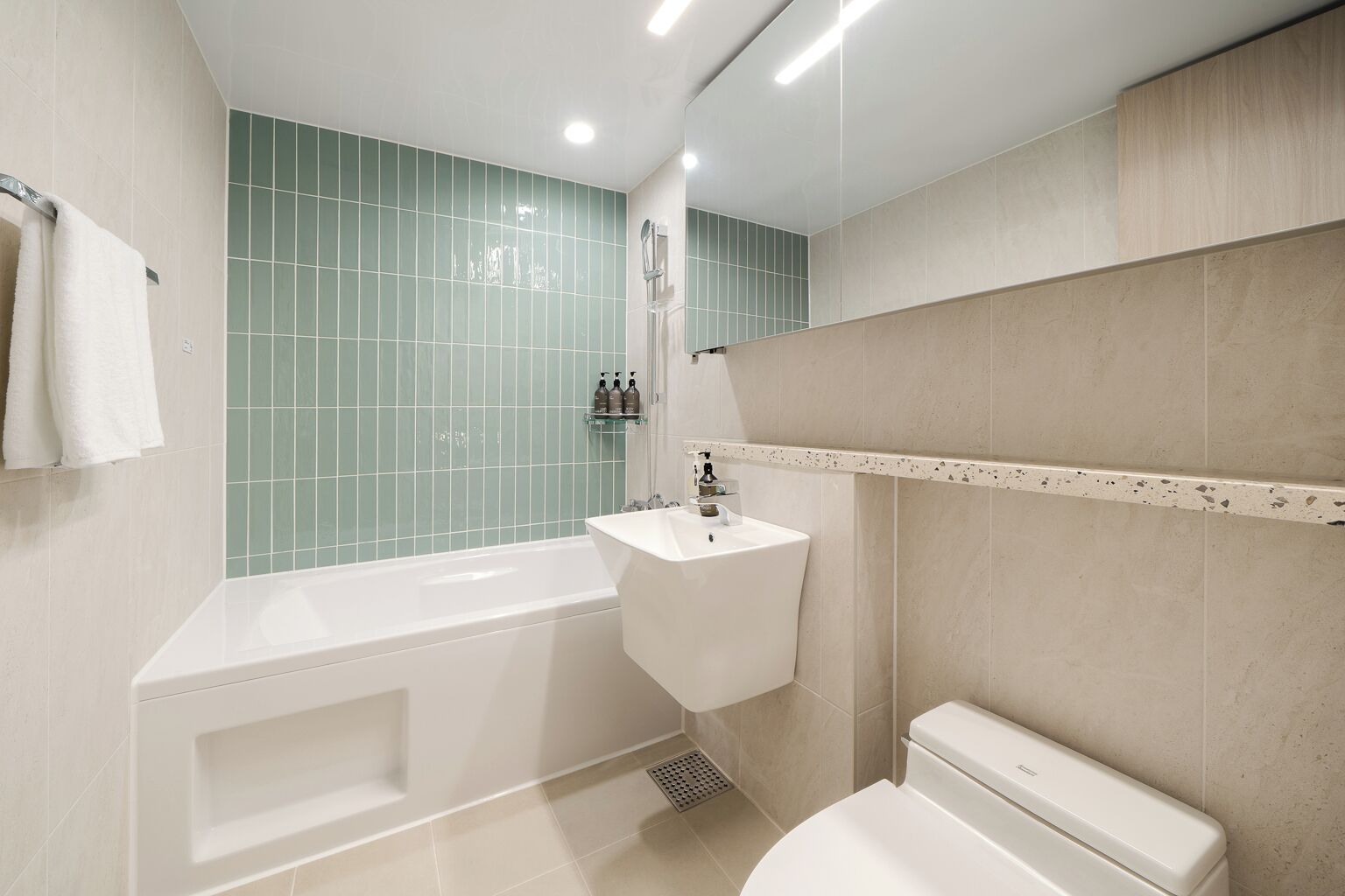 A modern bathroom with a bathtub, sink, and toilet.