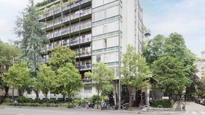 Un immeuble à plusieurs étages doté de balcons, d’une entrée sécurisée et de vélos garés à l’extérieur.